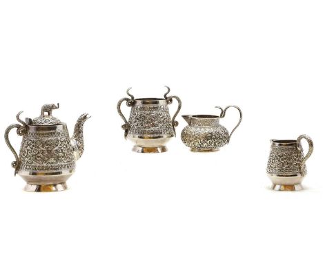 An Indian three piece silver tea service, 20th century, Cutch pattern, each piece of tapering form, comprising a teapot, 11.5