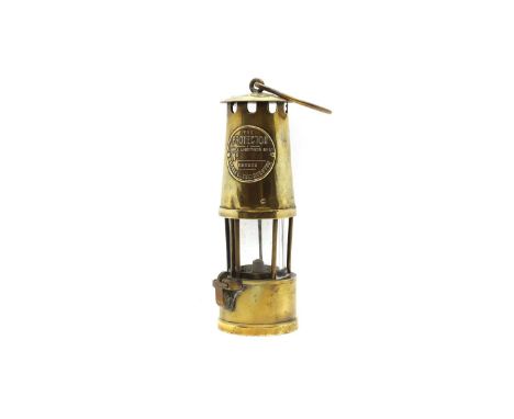 'The Protector': A brass miner's lamp Eccles, Manchester, with a cylindrical glass shade and suspension hook,total 34cm highC