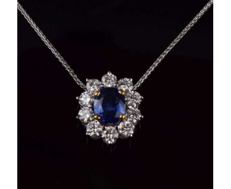 Sapphire and diamond cluster pendant, in unmarked white metal, the oval cut sapphire stated as weighing 2.12cts, enclosed by 