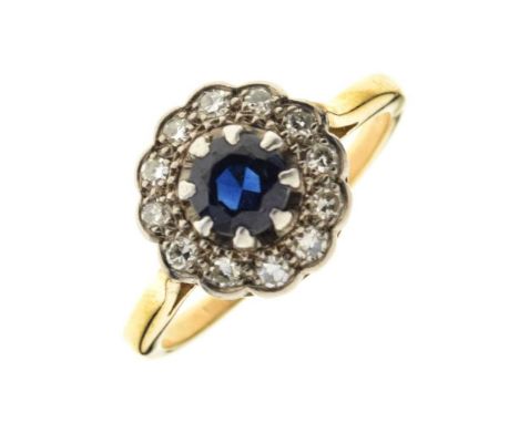 Sapphire and diamond cluster ring, stamped '18ct', the round cut sapphire enclosed by twelve single cuts, size N, 3.8g gross 