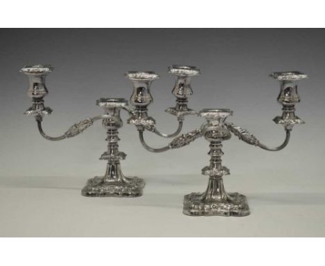 Pair of Elizabeth II silver three-light, two-branch candelabra with scroll arms and molded foliage decoration standing on sha