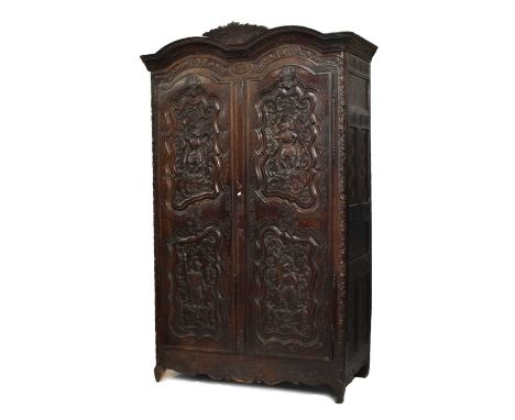 Late 18th or early 19th Century French carved stained oak and fruitwood armoire, with double-humped foliage-carved cornice an