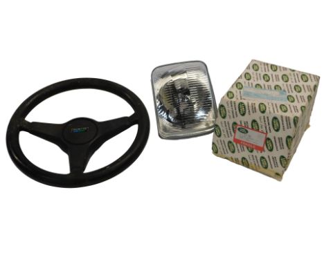An Austin steering wheel, and a Land Rover 1XSTC766 head lamp assembly left hand. (2) 