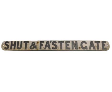 A cast iron Shut and Fasten the Gate sign.