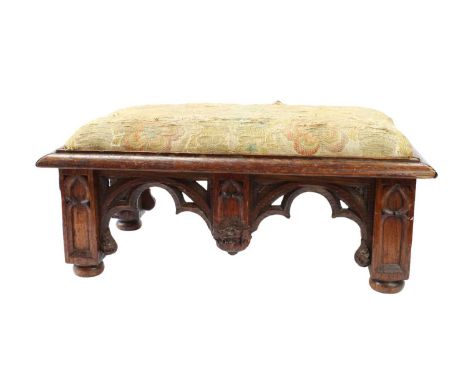 Late 19th Century Gothic Revival Carved Oak Stool With tapestry upholstered cushion raised on four carved arcaded supports to