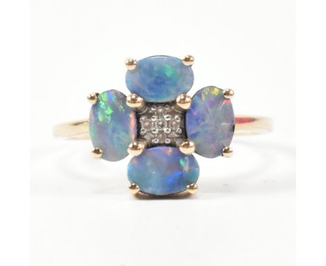 A hallmarked 9ct gold and opal doublet ring. The ring having four button prong set oval cut opal doublets set in a flower sha