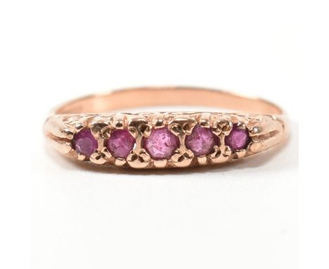 A hallmarked 9ct rose gold and ruby five stone gypsy ring. The ring having five graduating round cut rubies set in a 9ct rose