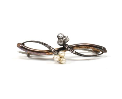 An early 20th century gold diamond and pearl brooch pin. The brooch in the form of a branch with old cut diamond and pearl fi