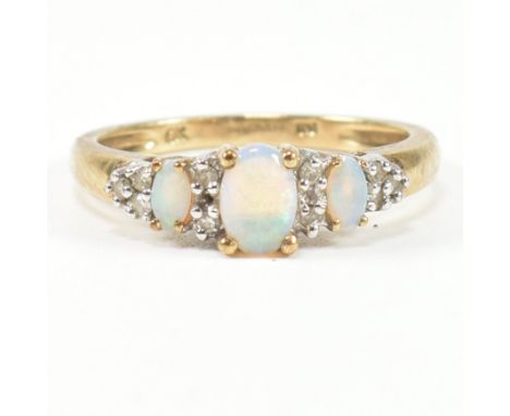 A hallmarked 9ct gold, opal and diamond three stone ring. The ring having three graduating oval opal cabochons interspaced by