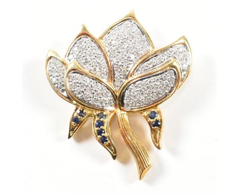 A hallmarked 18ct gold, sapphire and diamond lotus flower brooch pin. The lotus flower brooch pin having petals set with pave