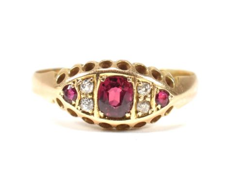 An Edwardian hallmarked 18ct gold ruby and diamond ring. The ring set with a central oval cut ruby flanked by round cut rubie