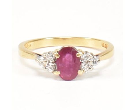 A hallmarked 18ct gold, ruby and diamond ring. The ring set with a central oval cut ruby flanked by six round cut diamonds to