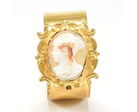 A 19th century shell cameo double hinged gilt bangle. The Georgian bangle having a central carved cameo set panel within a fo
