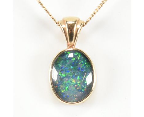 A hallmarked 9ct gold and opal doublet pendant necklace. The necklace having a bezel set opal doublet cabochon strung on a go