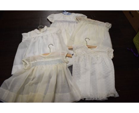 Five newborn baby garments, comprising five hand knitted garments in cream crochet: a bonnet with pink ribbon tie, a top with