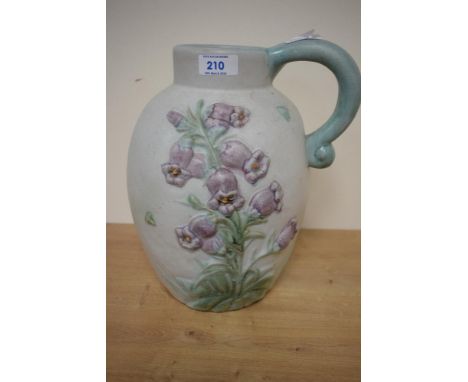 A large early 20th century Danesby ware ceramic jug, decorated having blue bell reliefs on an eggshell ground, h28cm
