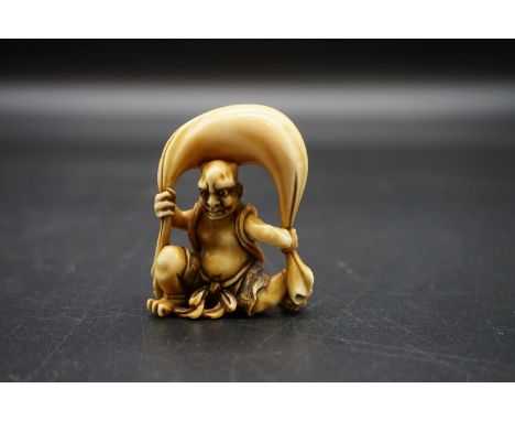 A good Japanese carved ivory netsuke, 19th century, depicting Fujin with his bag of wind, 4.5cm high. 