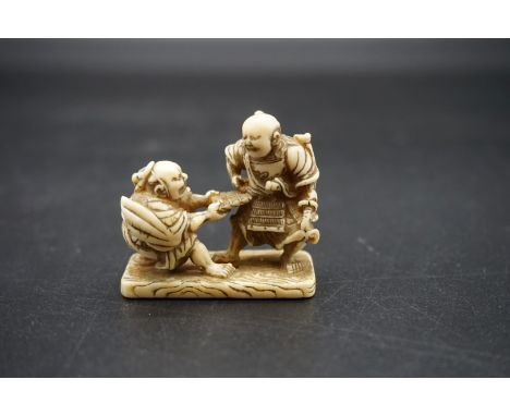 A good Japanese carved walrus ivory netsuke, Edo, depicting two Samurai, 4.7cm wide. 