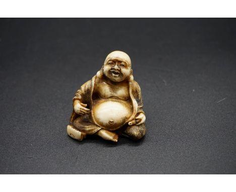 A Japanese carved ivory netsuke of Hotei, Meiji, signed, 3.7cm high. 