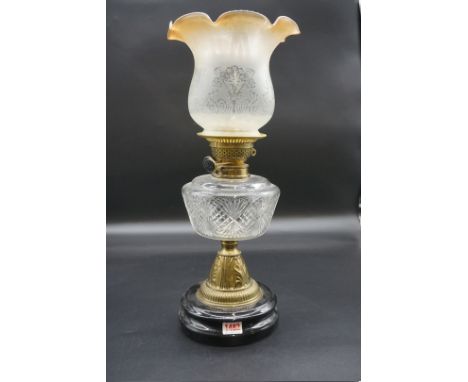 An antique brass oil lamp,&nbsp;with amber stained shade, height including shade 50cm.&nbsp; 