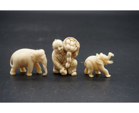 A Japanese carved ivory netsuke, early 20th century, depicting a man with a basket of fruit, 4.5cm high; together with two sm