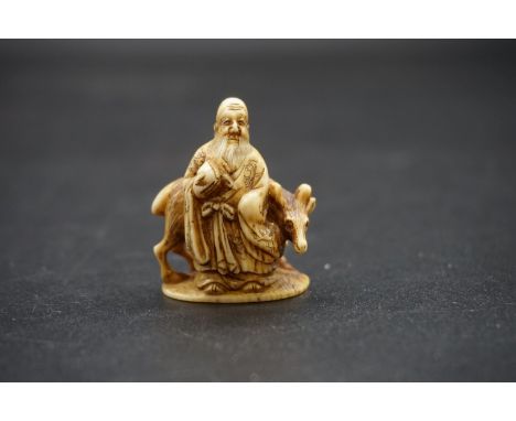 A Japanese carved ivory netsuke, 19th century, depicting a man and a deer, signed, 3.4cm high. 