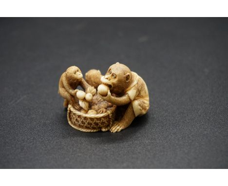 A good Japanese carved ivory netsuke, Meiji, depicting three monkeys eating peaches from a basket, 4cm wide. 