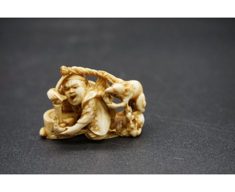 A good Japanese carved ivory netsuke, 19th century, depicting a man with a rat, signed, 4.6cm wide. 