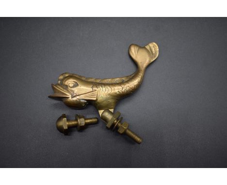 An antique brass dolphin door knocker,&nbsp;12.5cm long.&nbsp; 