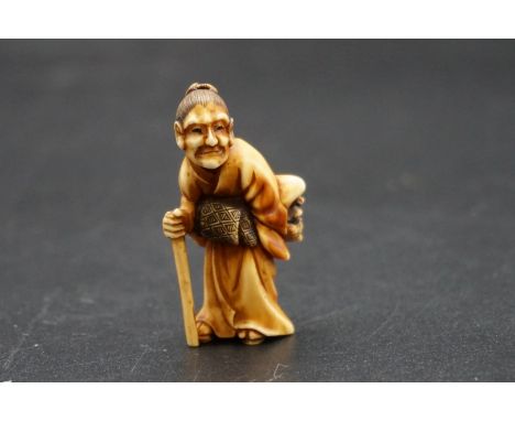 A good Japanese carved ivory netsuke, Meiji, depicting an elderly lady with a Noh mask and stick, 4.5cm high. 