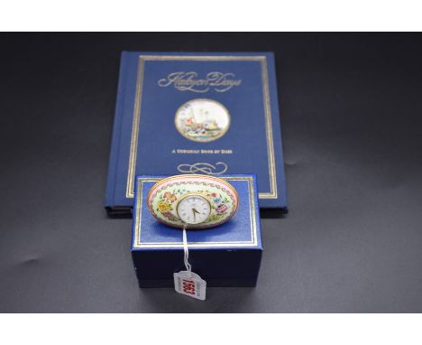A Halcyon Days enamel timepiece,&nbsp;7.5cm wide, boxed; with Halcyon Days diary. 