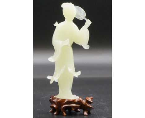 A Chinese carved celadon jade figure of Guanyin, 15cm high,&nbsp;on fitted wood stand, (s.d.). 