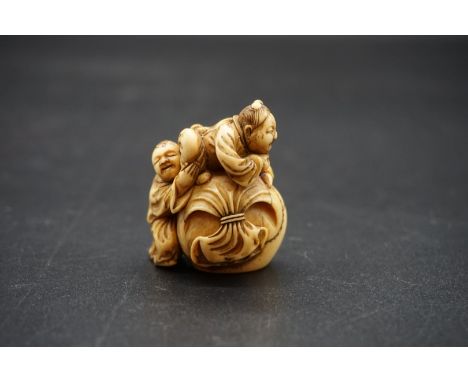 A good Japanese carved ivory netsuke, Edo, depicting two figure with a large treasure sack, 4cm high. 