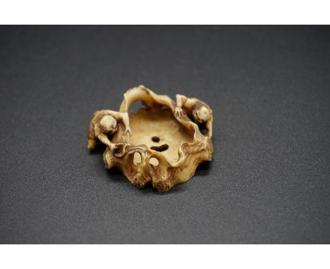 An unusual Japanese carved ivory netsuke, Meiji, depicting two demons and a tree stump, 4.3cm wide. 