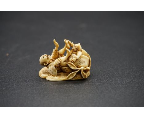 A good Japanese carved ivory netsuke, by Ryoji, 19th century, depicting a man and demon in comical pose, signed, 3.5cm wide. 