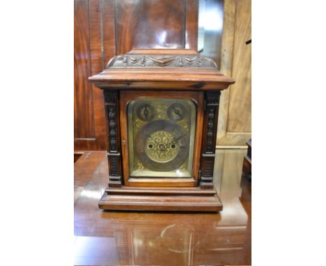 A late 19th century carved walnut twin fusee mantel clock, 34cm high, with pendulum.&nbsp; 