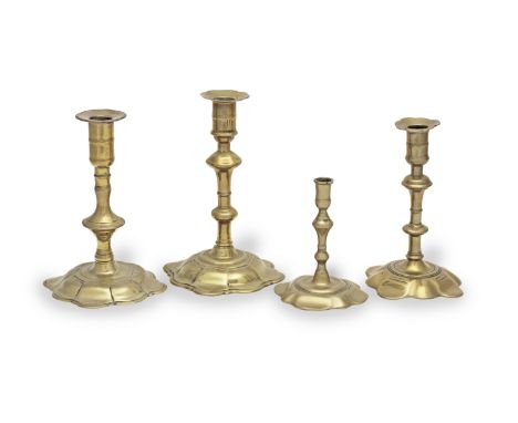 Three George II/George III brass alloy socket candlesticks, circa 1745-65All with petalled bases, one with a stem cast with a