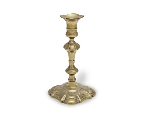 A George II brass socket candlestick, circa 1740With its apparently original loose nozzle, its edge cast with alternating con