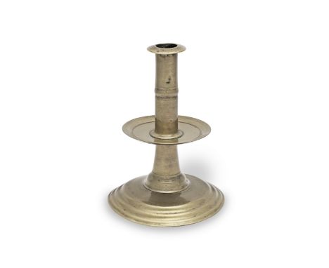 A rare and fine mid-17th century brass alloy trumpet-based socket candlestick, English, circa 1650The upper stem cast with a 