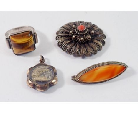 A silver tigers eye ring, yellow metal hair locket, filigree coral brooch (pin a/f) and a white metal stone set brooch 