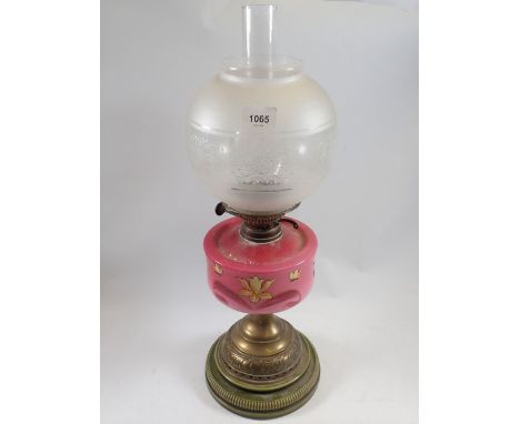 A Victorian oil lamp with pink floral painted glass reservoir, stoneware and brass base and etched glass shade 