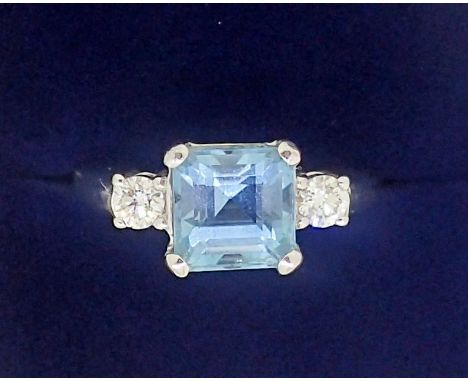 An 18 carat white gold ring set aquamarine flanked by two diamonds, size K to L, 5.5g 