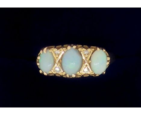 An 18 carat gold ring set three opals and four chip diamonds, size N, 3.1g 