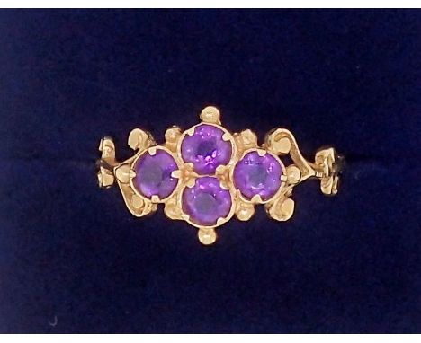 An antique style 9 carat gold ring set four amethysts in scrollwork and beaded surround, 1.6g, size M 