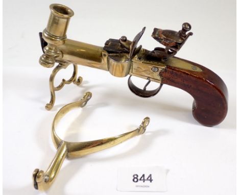 An antique percussion action pistol table lighter with taper stick, 17cm long and a brass stirrup 