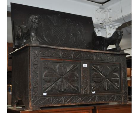 A 1920s carved and panelled oak monk's bench, width 96cm.