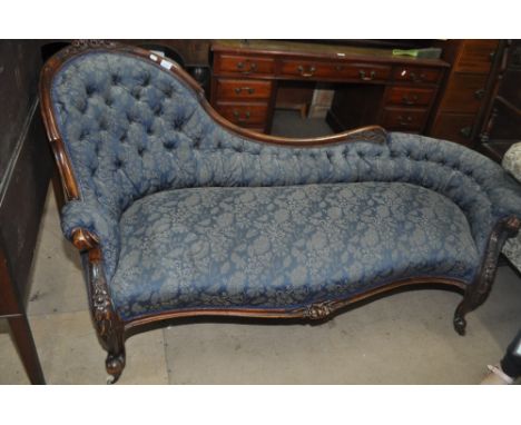 A Victorian carved mahogany framed and spoon back salon sofa, with button blue upholstery on cabriole legs, length 180cm.