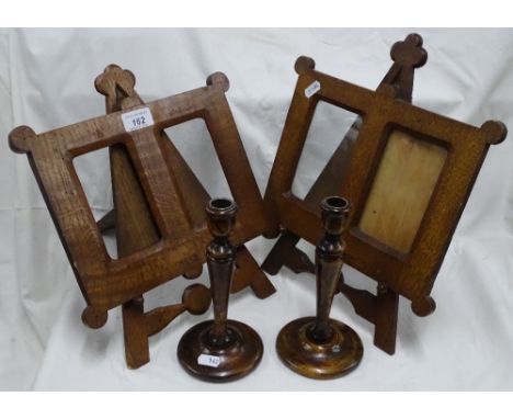 A pair of oak easel design double frames and a pair of candlesticks.