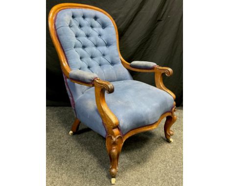 A Victorian mahogany armchair, button-back, scroll arms, sprung seat, serpentine shaped front, carved cabriole legs, ceramic 