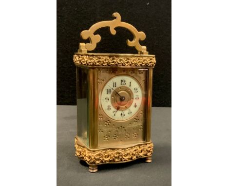 A late 19th century French time piece carriage clock, slight serpentine case with floral banded detailing, cream Arabic numer